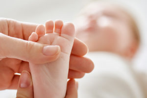 A person holds a baby's foot.