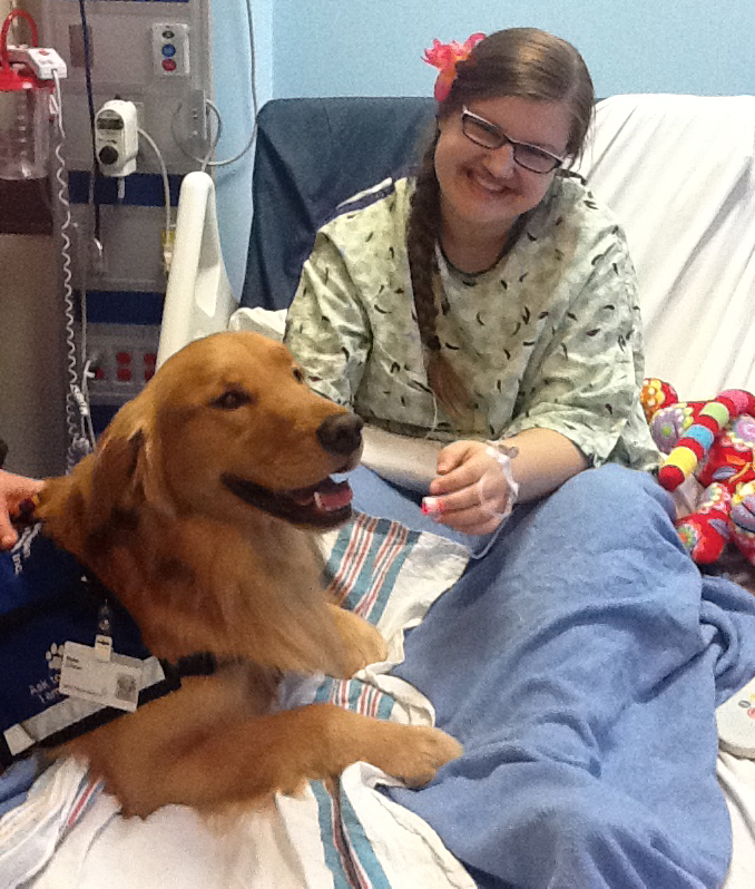 Mikaela Sterenberg gets a visit from a pet therapist while staying at Spectrum Health Helen DeVos Children's Hospital.