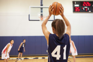 Young girls are playing a basketball game.