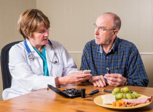 A medical professional talks with an elderly man about diabetes.