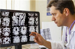 A medical professional looks at an MRI.