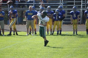 Hunter VeltKamp throws a football on a football field at Central Montcalm High School.