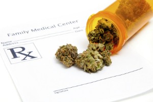 A bottle full of marijuana spills onto a "Family Medical Center" prescription sheet.