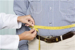 A man gets his waist measured with measuring tape by a medical professional.