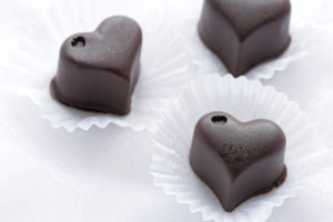 Three dark chocolate candies are in focus.