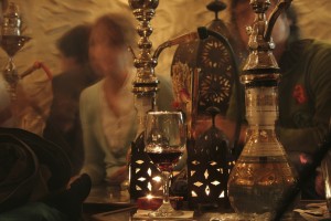 A group of people smoke at a hookah lounge.