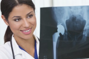A medical professional looks at a medical image of a person's hip.
