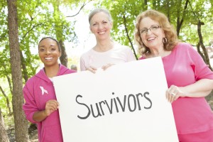 Three women hold up a "Survivors" sign.