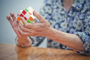 A woman with Parkinson's Disease pain plays with a Rubik's cube.