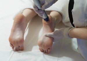 A medical professional performs an ultrasound technique on a patient's foot.