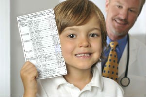 A young boy holds a vaccine poll in his hand.
