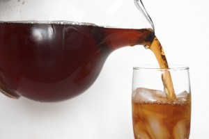 Iced tea is shown being poured into a glass.