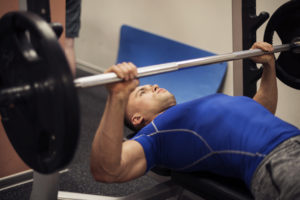 A man lifts weights at a gym.