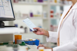 A pharmacist is shown writing a prescription.
