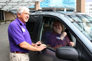 Volunteer Dave Wait chats with a woman in a car.