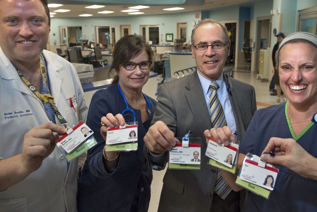 Dr. Robert Connors and some staff on the 6th floor at Spectrum Health Helen DeVos Children's Hospital show their identification badges that have been modified to feature their first names. 