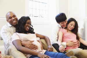 Two couples attend a childbirth class. They appear happy.