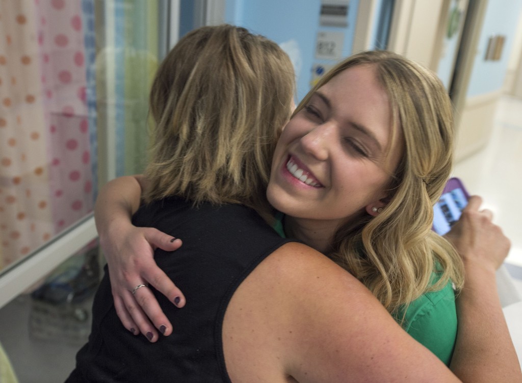 Music therapist Bridget Sova gets a hug from Erin Fredericks, a young patient's mom at Spectrum Health Helen DeVos Children's Hospital.