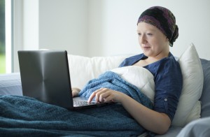 A cancer patient uses their computer to talk on social media about their condition and health care journey.