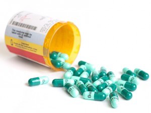 A pill bottle filled with antibiotics is shown.