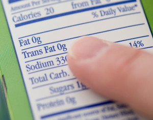 A person points at the 'Fat' section on a nutrition label.