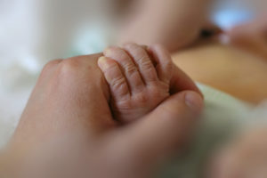 A person holds a baby's little hand.