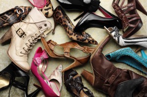 A pile of high-heeled shoes are shown on the floor.