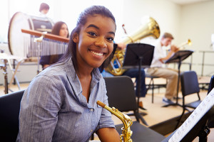 A woman poses for a photo in a band room.