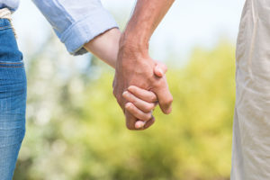 A woman and man hold hands.