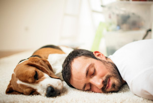 A man naps with his dog.