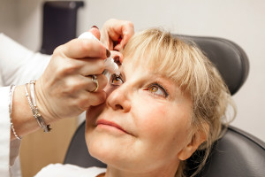 A woman receives cataracts drops in her eye during an appointment.