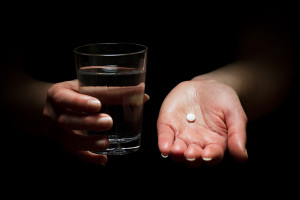 A person holds a painkiller in their hand.