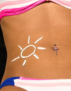 A woman lies in the sun with sunburn art on her stomach.