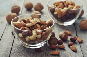 Two bowls are filled with peanuts and other nuts.