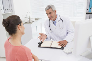 A woman talks to her doctor about her health journal.