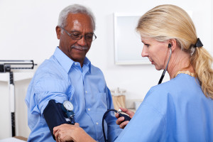 A man gets his blood pressure measured by a medical professional.
