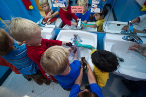 A group of kids wash their dirty hands together.