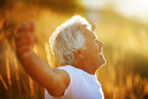 An elderly man embraces the sun.