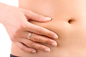 A woman holds onto her belly fat.