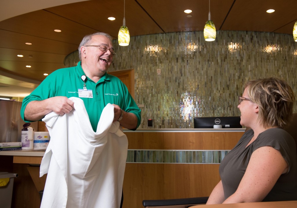 Richard Karns laughs with a woman as he volunteers at the Susan P. Wheatlake Regional Cancer Center in Reed City.  