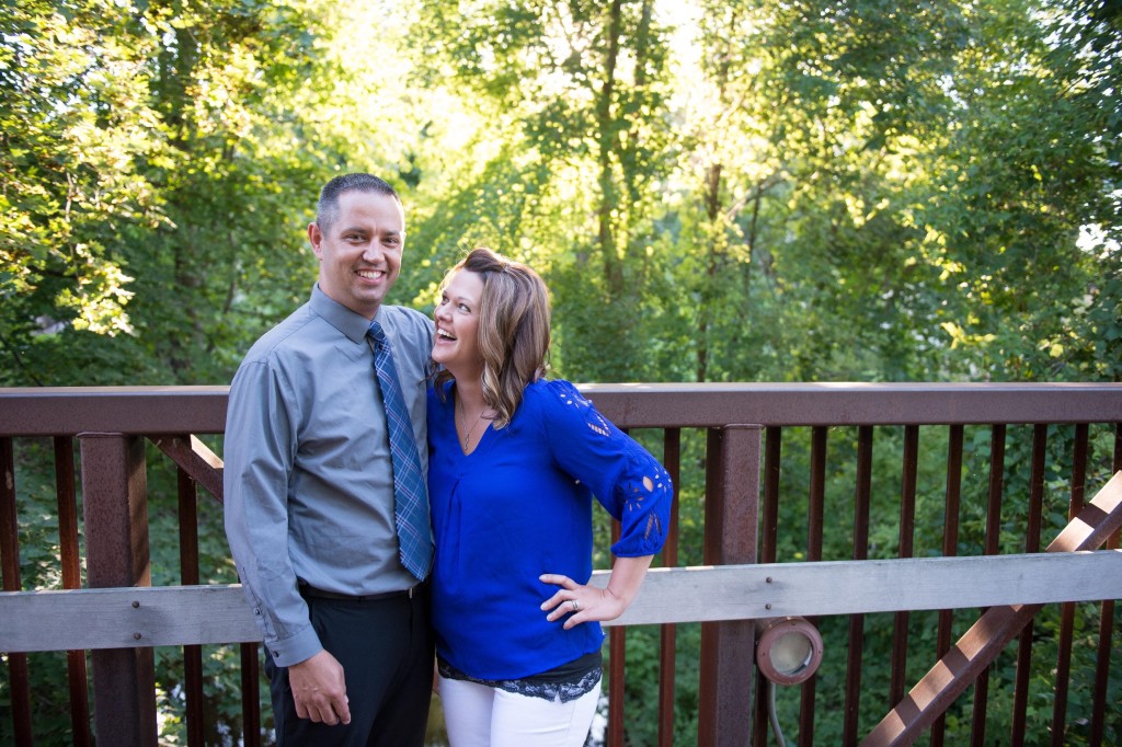 Jeff and Michelle Godfrey pose for a photo on a bridge and smile.