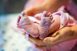 A mother holds her newborn baby's tiny feet.