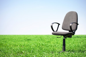 An office chair sits in green grass.