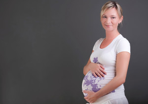 A pregnant woman poses for a photo.