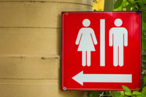 A red restroom sign is in focus.