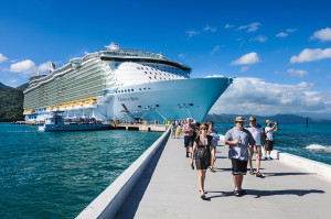 A cruise ship is shown with people exiting through the dock area.