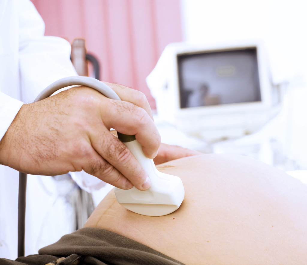 A pregnant woman is getting an ultrasound scan.