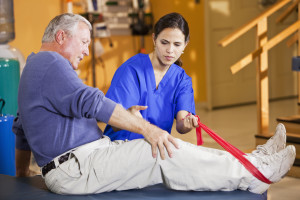 An elderly man participates in physical therapy for his knee.