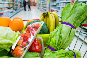 A grocery cart is shown with fruits and vegetables.