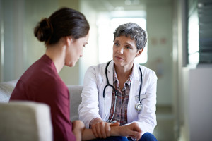 A woman talks to a medical professional at an appointment.